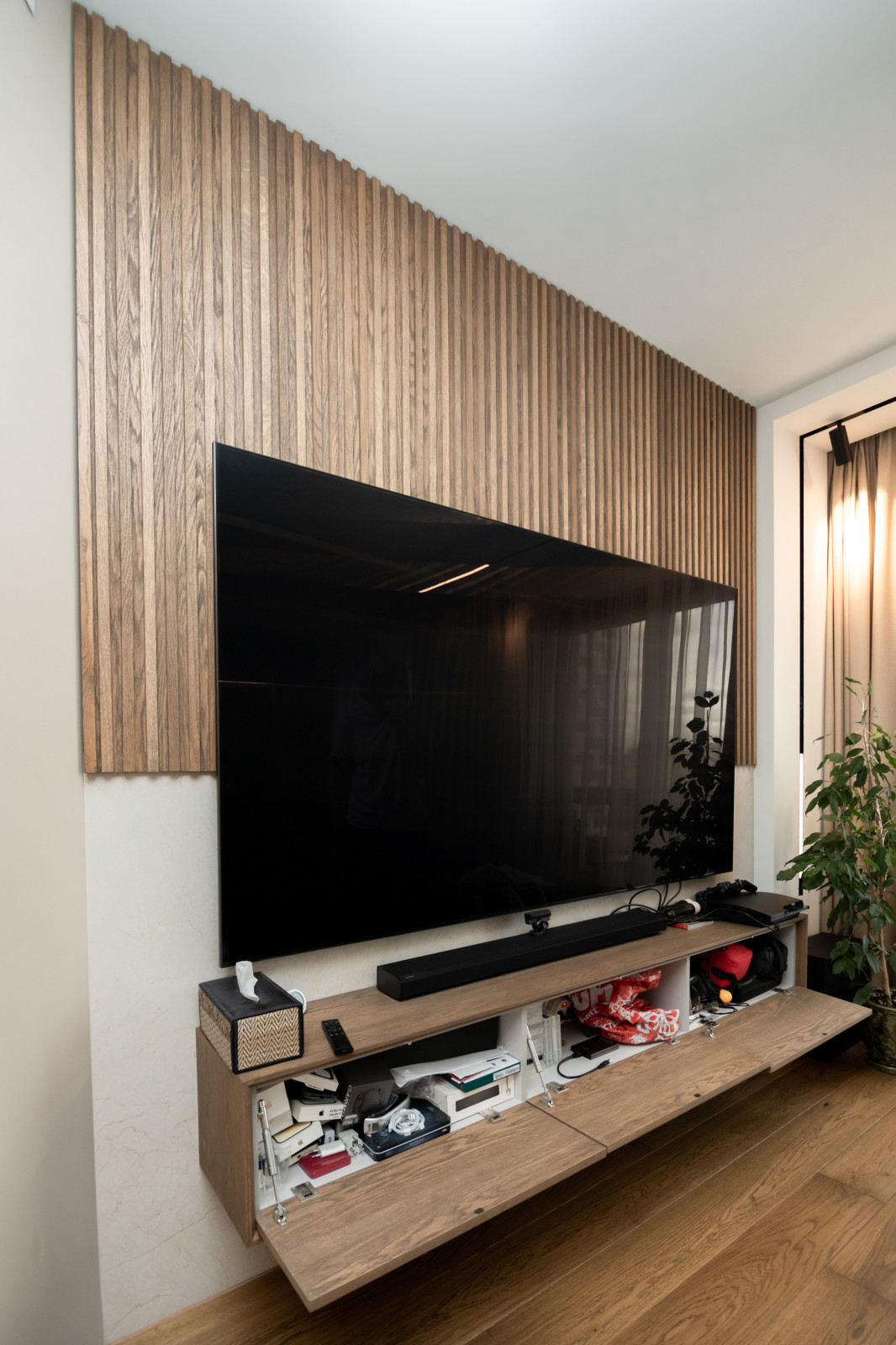 Современная кухня-гостиная с необычной барной стойкой и ТВ-зоной